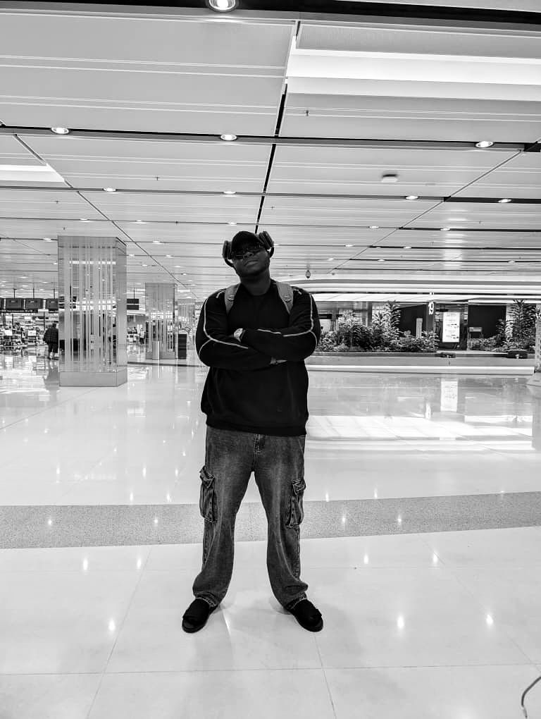 Harold standing with arms crossed in a Singapore airport hall