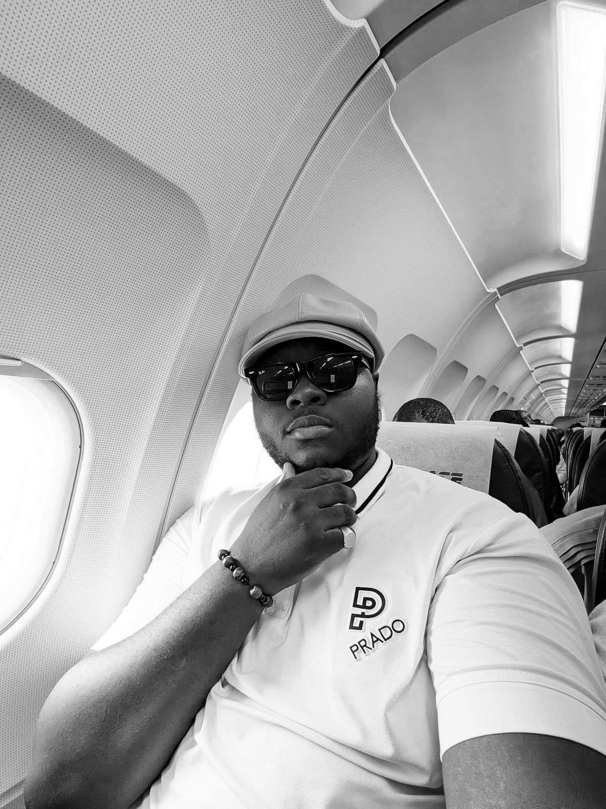Harold in a window seat, hand on his chin, on the way to the Blockchainful event in Lokoja